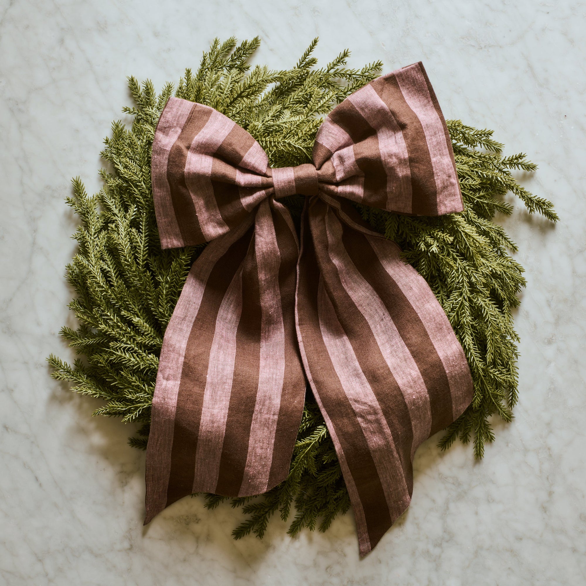 Wreath with a brown striped bow on a light background